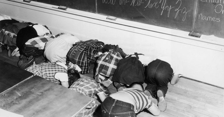 1950s children practicing duck and cover for bomb warnings